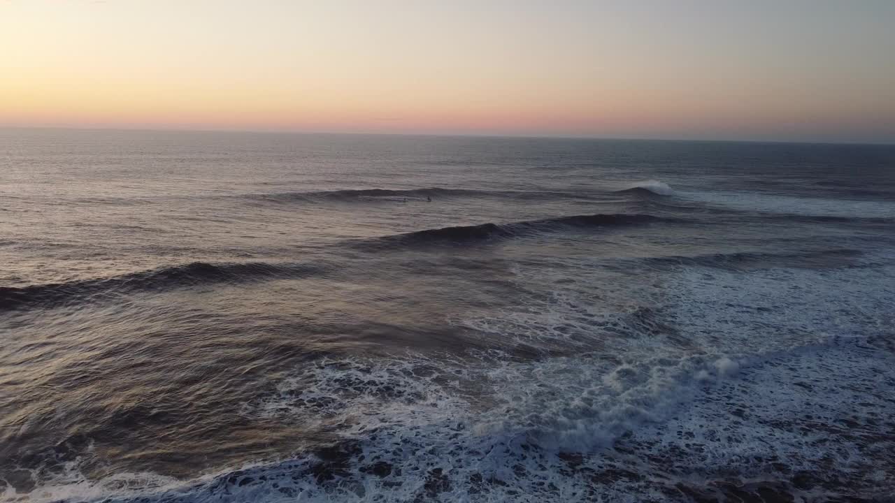 黄昏时分，航拍的巨浪翻滚在葡萄牙纳扎尔海岸视频素材