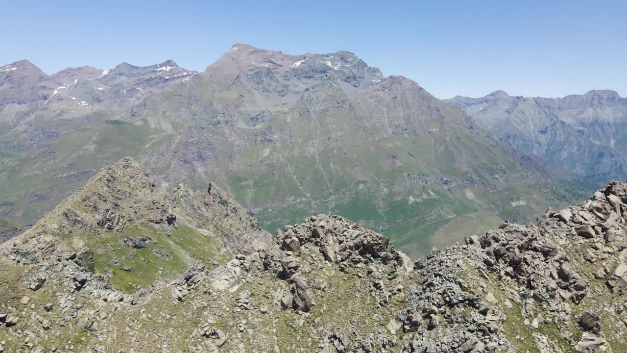 在一个阳光明媚的日子里，与徒步旅行者在落基山脉的山顶鸟瞰高地视频素材