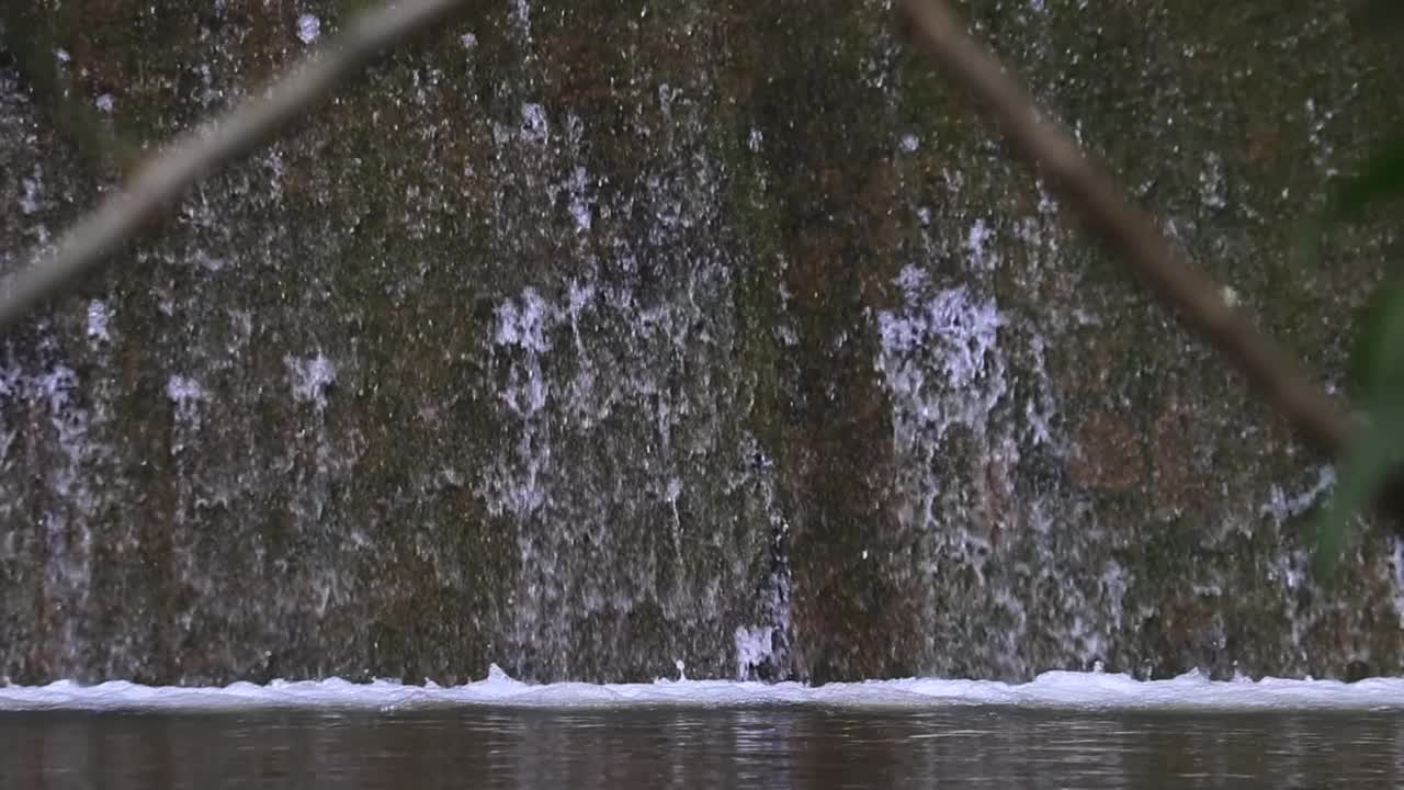 瀑布流水缓慢，瀑布岩石自然风光秀丽视频素材