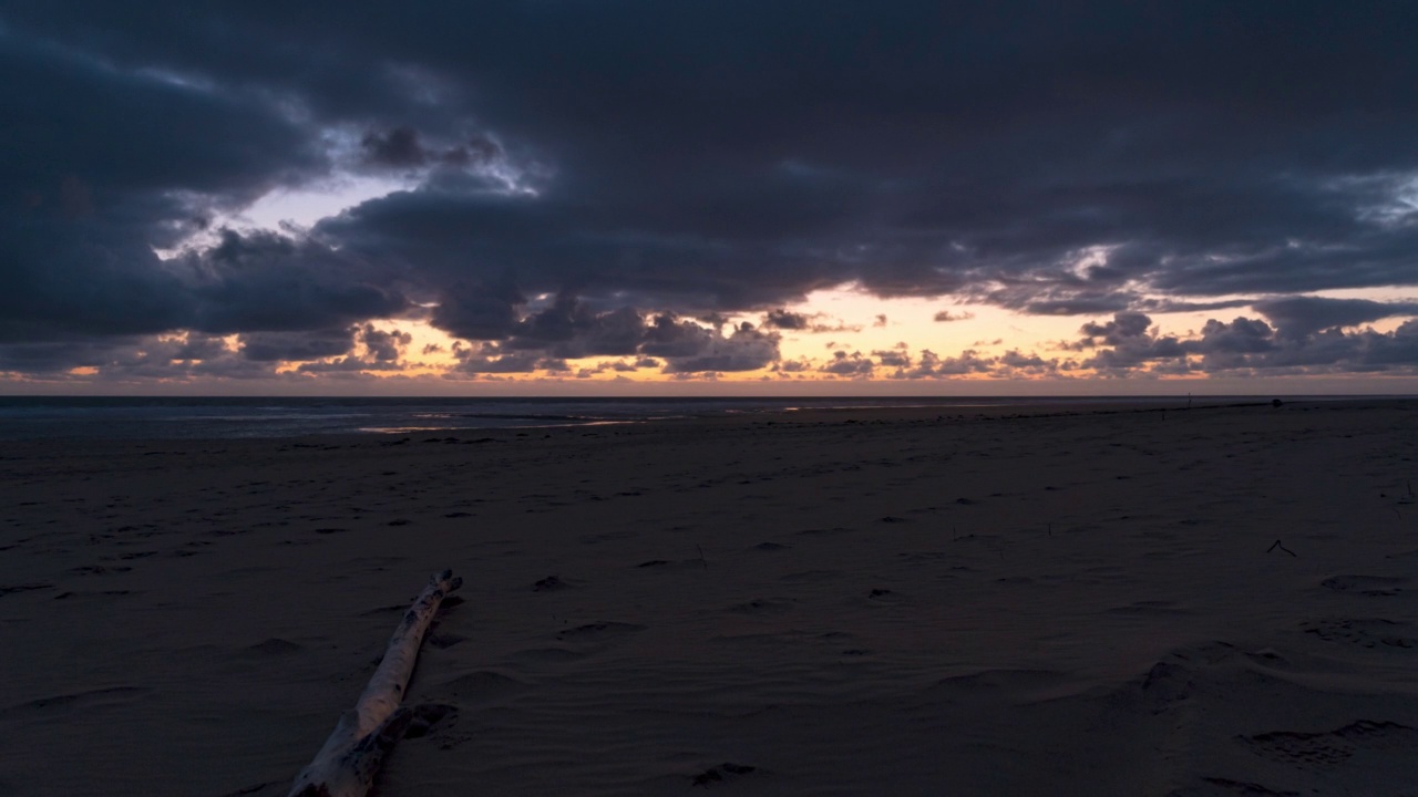 夕阳从库布雷灯塔的海滩上落下，云层下的太阳和沙上的倒影，夏朗特，法国视频素材