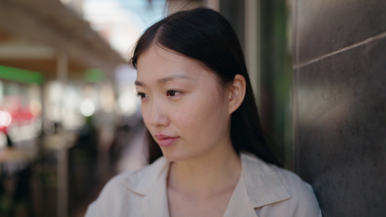 中国妇女自信地微笑着，看着街道的一边视频素材