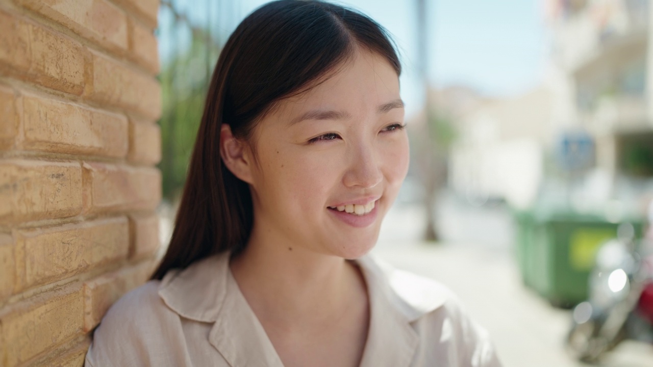 中国妇女自信地微笑着，看着街道的一边视频素材