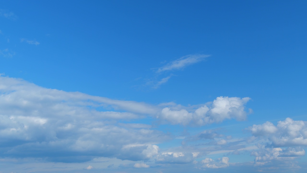 柔软的白云移动在蓝色的天空背景。热带夏天或春天的阳光。白天。时间流逝。视频素材