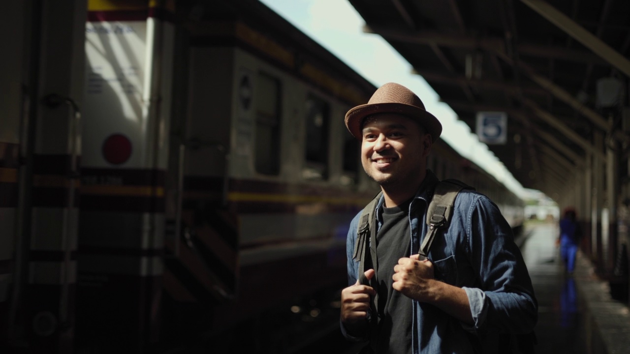 男性背包客到达站台铁路。自由旅行者年轻的亚洲人在终点站。快乐旅游旅游乘火车在假期时间假期周末旅行。去各地的概念。视频素材