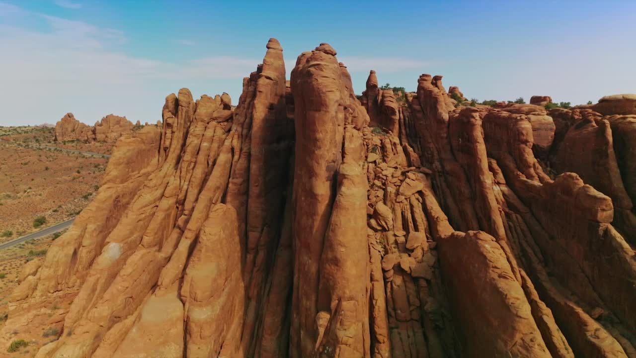 盘旋在形状怪异的山顶，山顶几乎没有绿叶。蓝色天空背景下美丽的岩石。视频素材