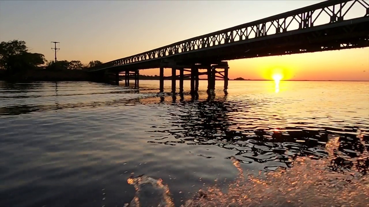 金色的夕阳掠过水面，桥下水花四溅视频素材