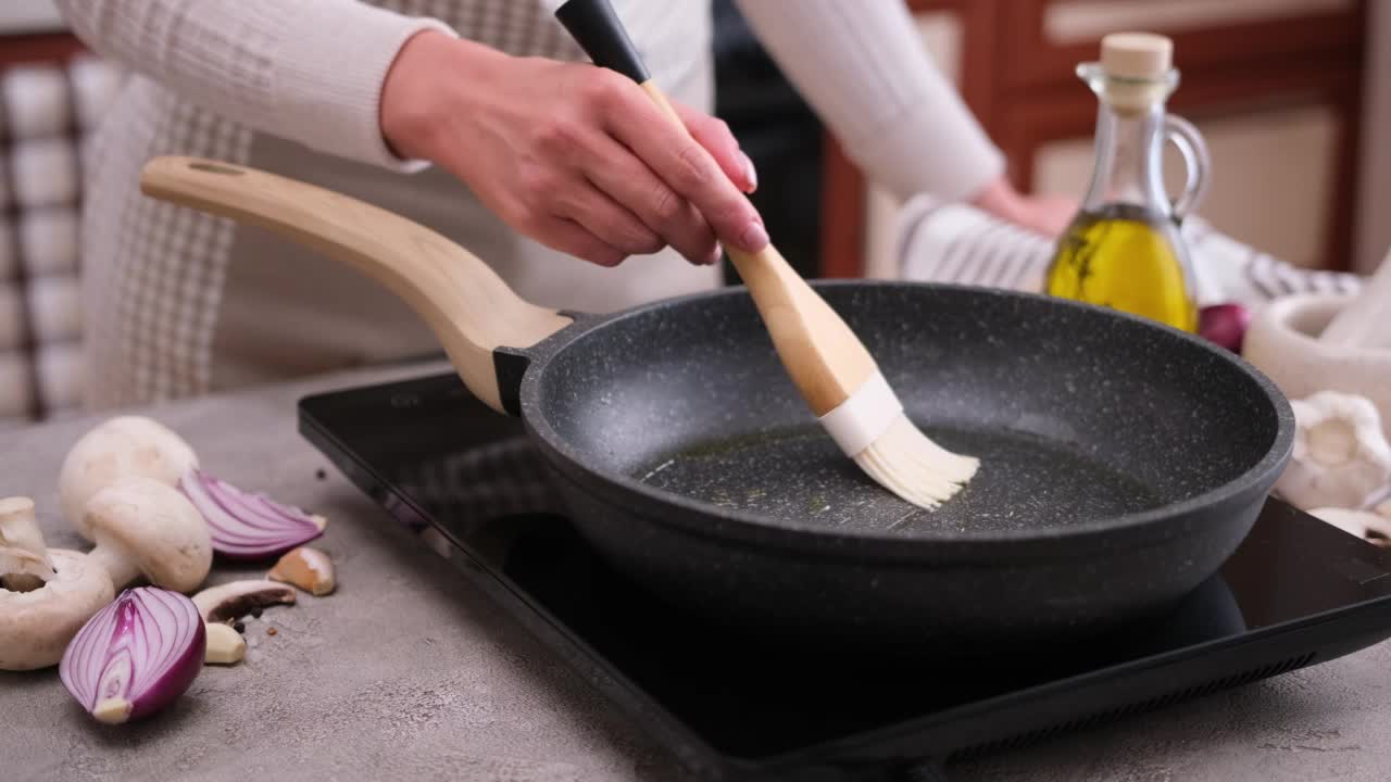 用刷子在煎锅上涂抹烹饪橄榄油的妇女视频素材