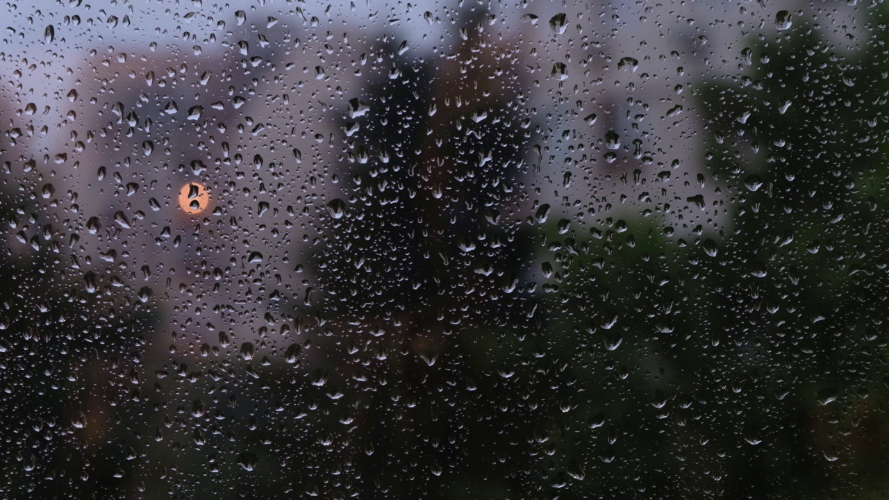 纹理的黑色背景与雨滴落在窗户玻璃上。视频素材