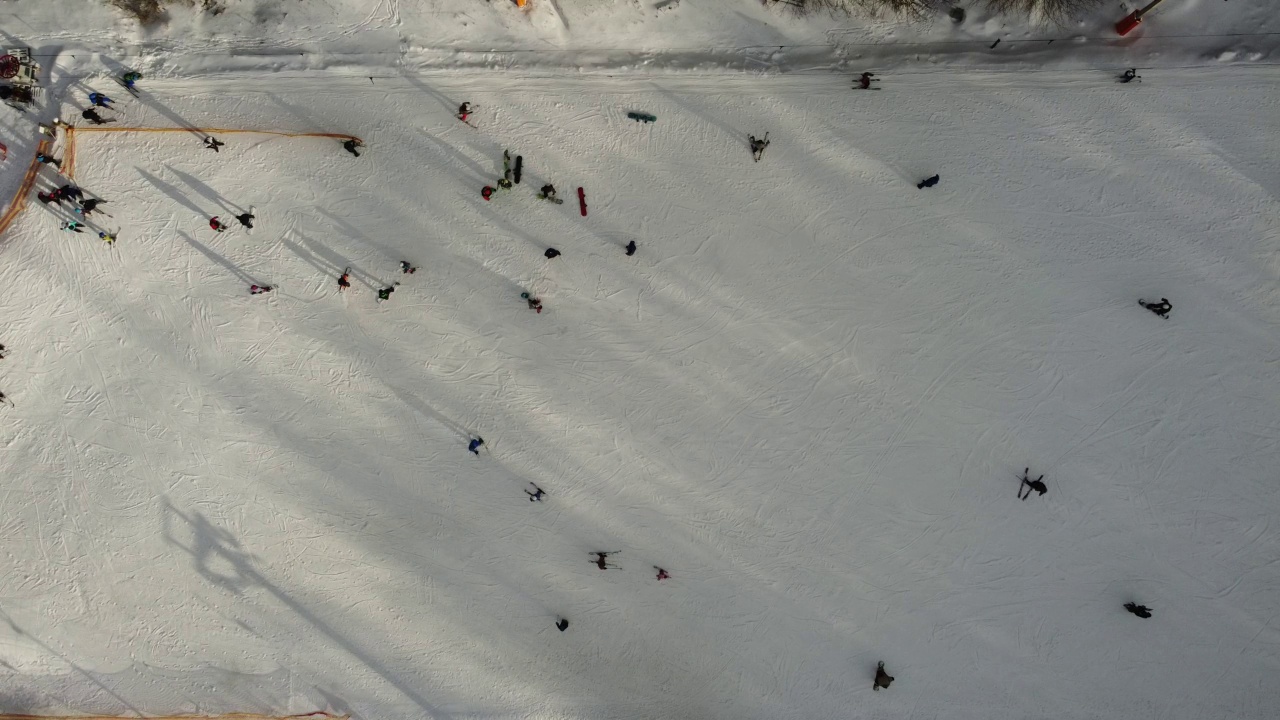 在滑雪场的斜坡上的无人机视图。从空中俯瞰森林和滑雪坡。无人机拍摄的冬季景观。滑雪胜地的雪景。航空摄影视频素材