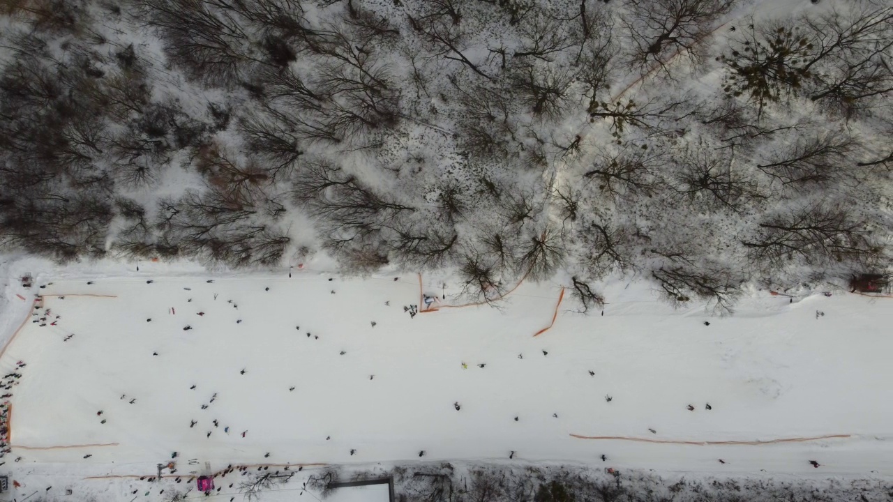 在滑雪场的斜坡上的无人机视图。从空中俯瞰森林和滑雪坡。无人机拍摄的冬季景观。滑雪胜地的雪景。航空摄影视频素材