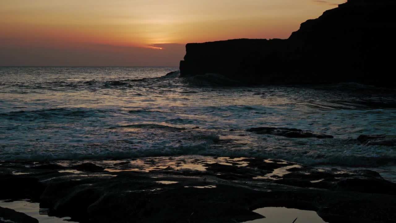 海边的日落，海边的海水和岩石，红色的天空视频素材