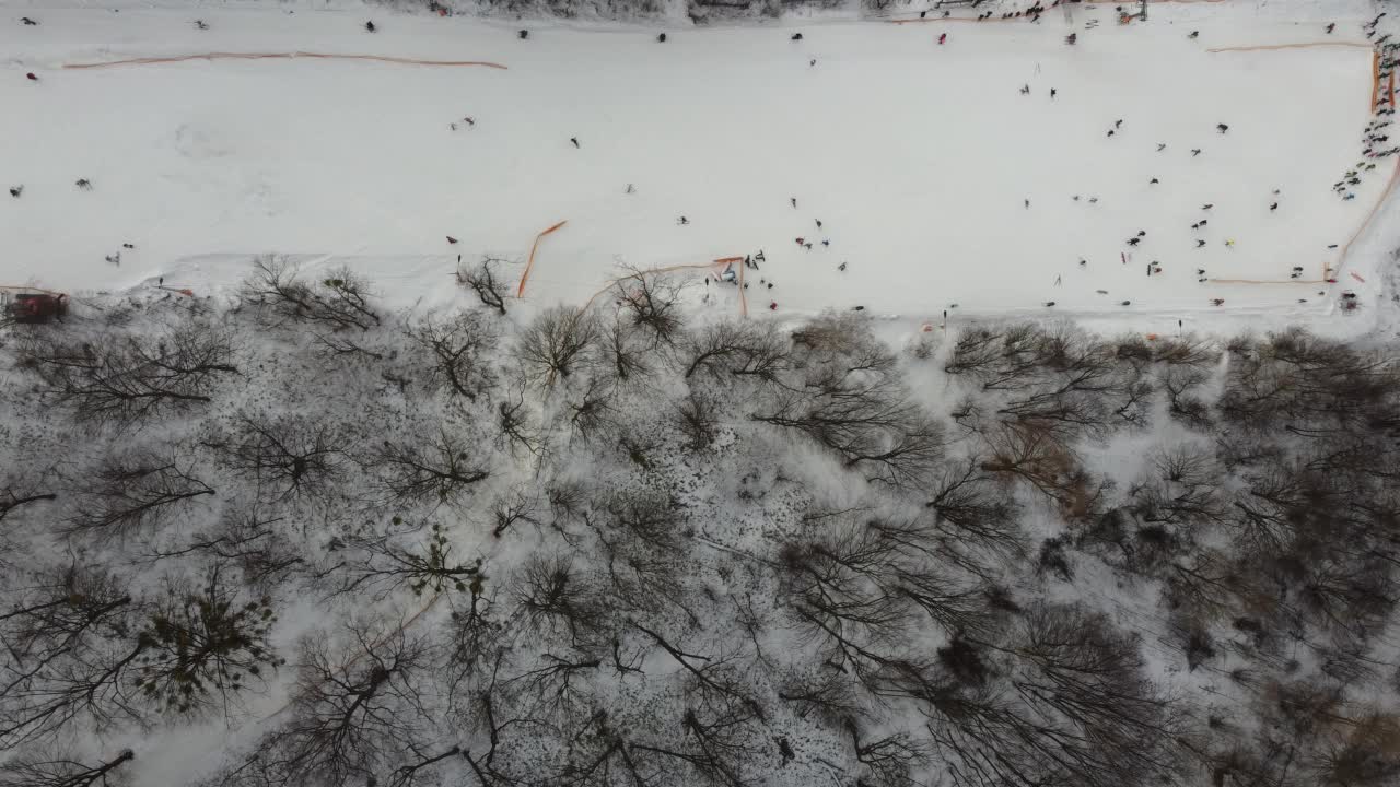 在滑雪场的斜坡上的无人机视图。从空中俯瞰森林和滑雪坡。无人机拍摄的冬季景观。滑雪胜地的雪景。航空摄影视频素材