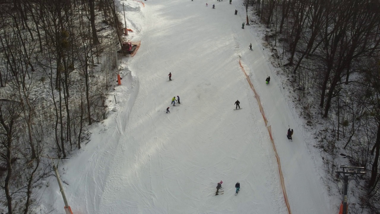 在滑雪场的斜坡上的无人机视图。从空中俯瞰森林和滑雪坡。无人机拍摄的冬季景观。滑雪胜地的雪景。航空摄影视频素材