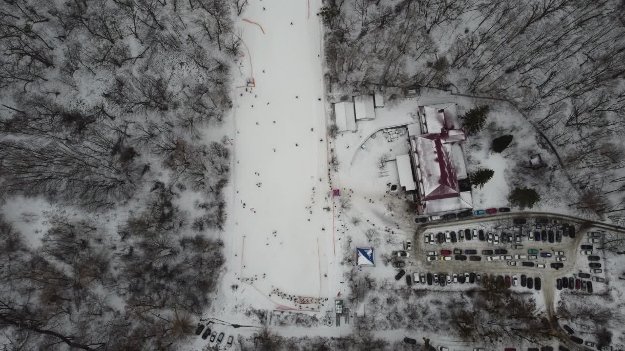 在滑雪场的斜坡上的无人机视图。从空中俯瞰森林和滑雪坡。无人机拍摄的冬季景观。滑雪胜地的雪景。航空摄影视频素材