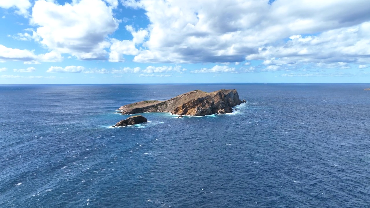 海浪在陡峭的小岛岸边撞击岩石视频素材