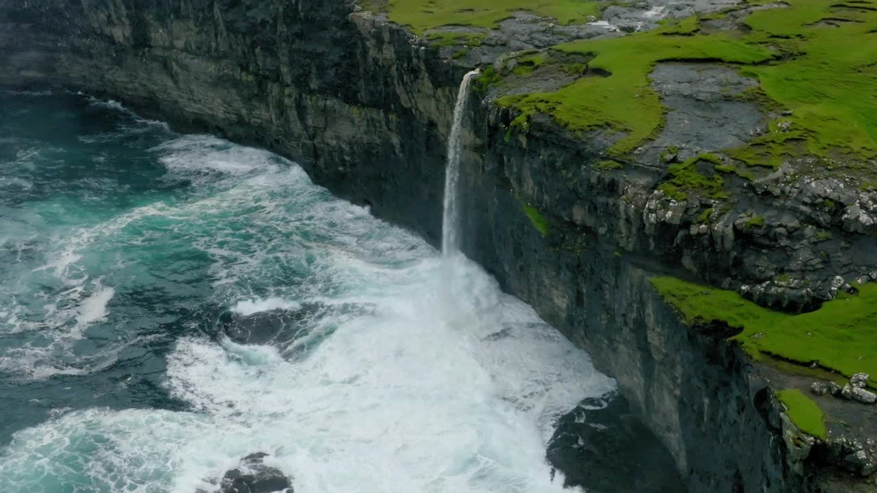 岛上瀑布的空中拍景，无人机在波浪海上向后飞行-法罗群岛，丹麦视频素材