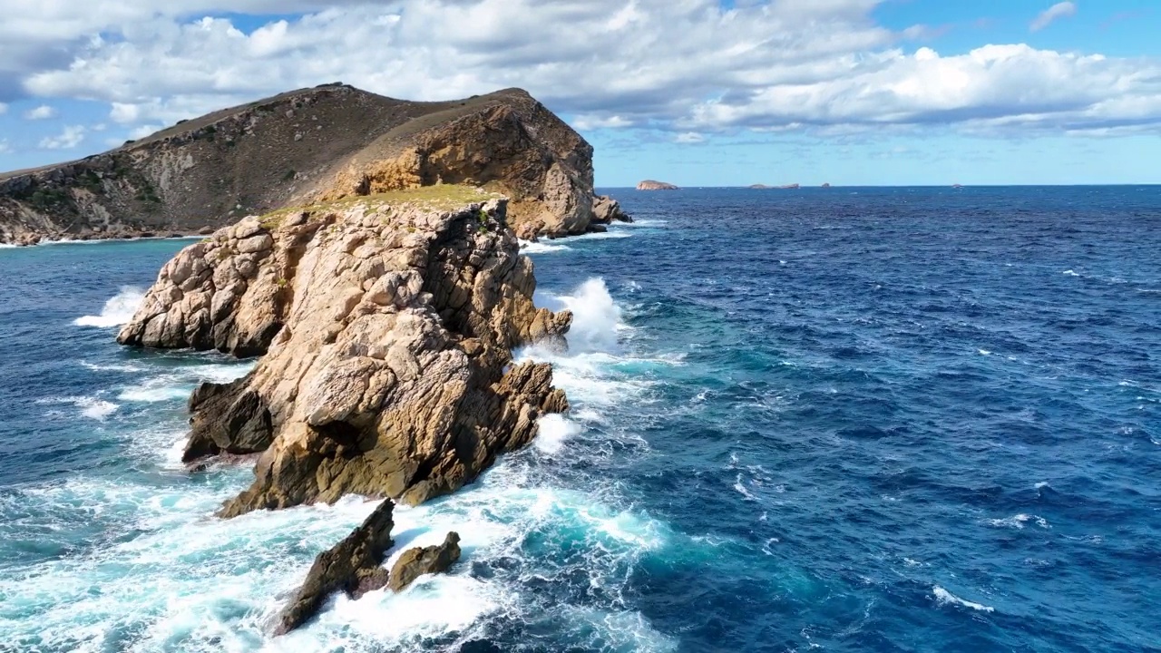 海浪在陡峭的小岛岸边撞击岩石视频素材