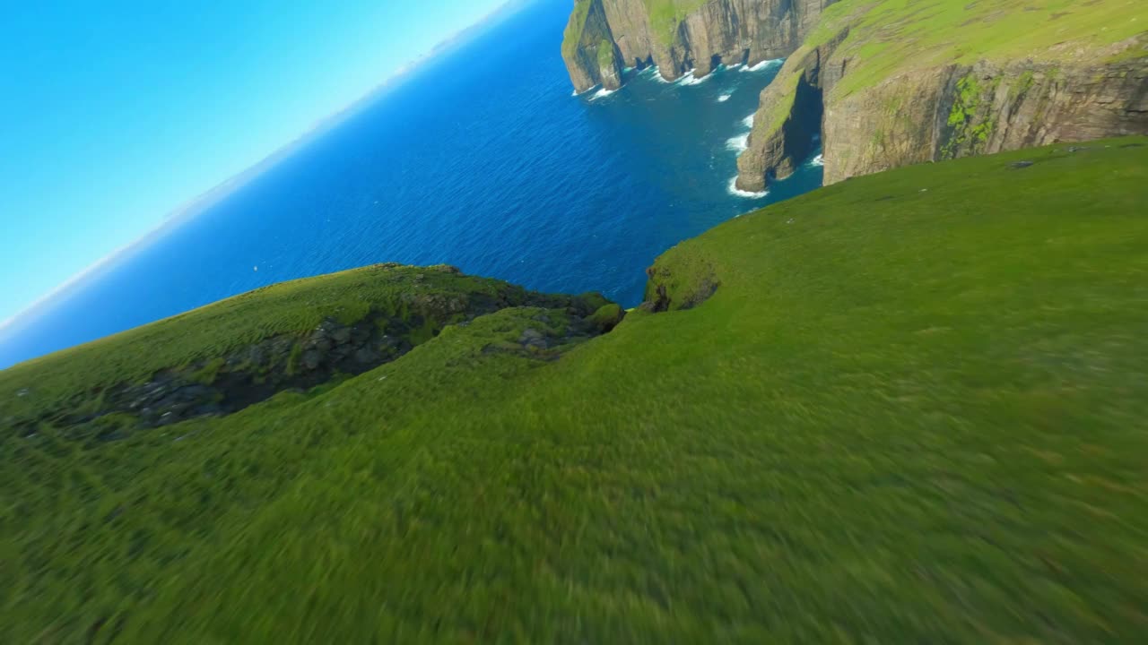 空中倾斜拍摄的海上天然岩层，无人机在阳光明媚的日子降落-丹麦法罗群岛视频素材