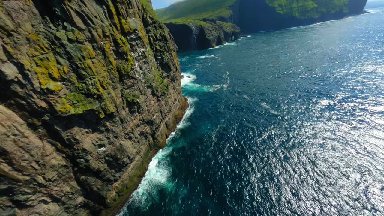 海上自然岩层的空中美景，无人机在阳光明媚的日子向前飞行-丹麦法罗群岛视频素材