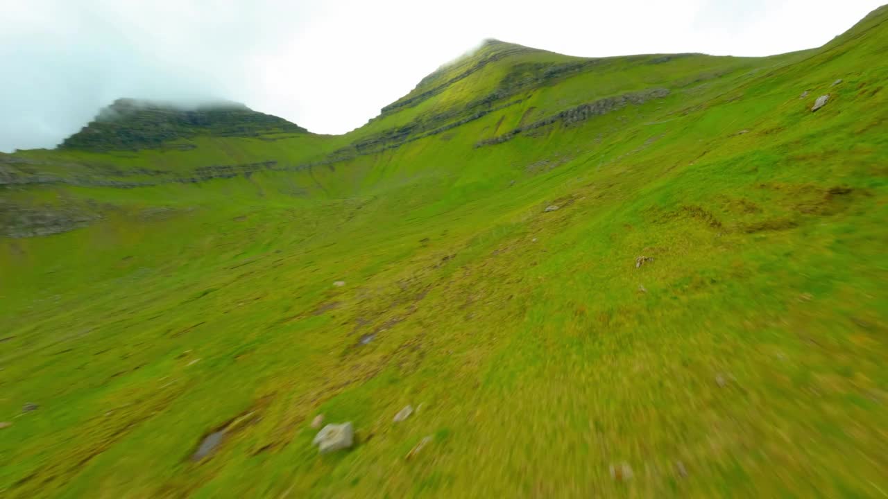 空中拍的青山对着天空，无人机向前飞越自然景观-法罗群岛，丹麦视频素材