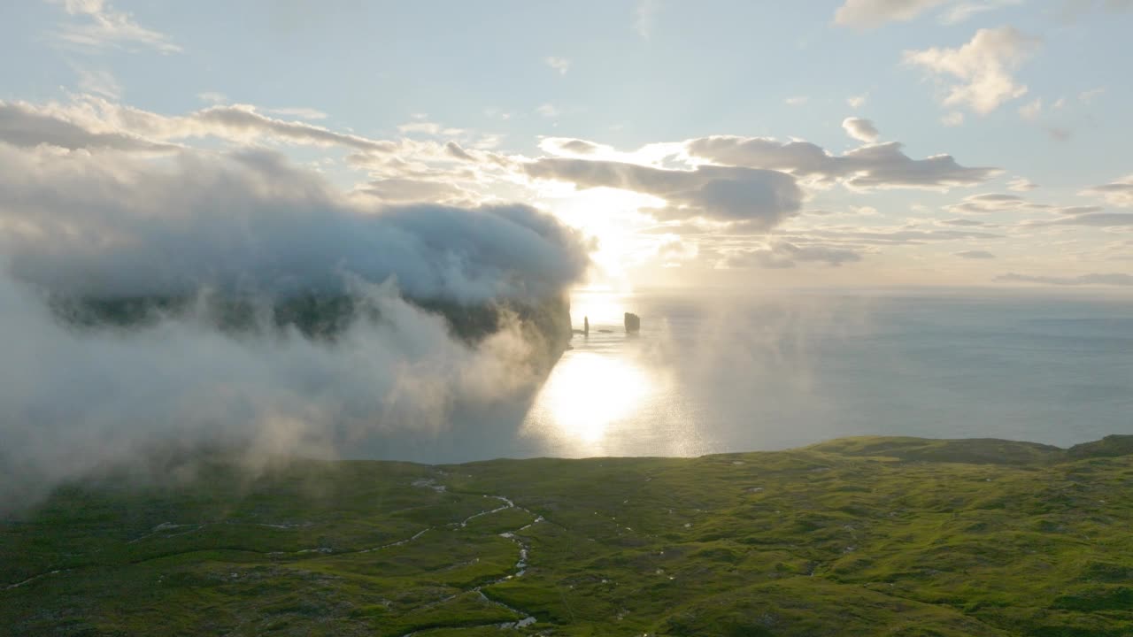 空中美丽的云在海上的山，无人机向前飞行在绿色的土地-法罗群岛，丹麦视频素材