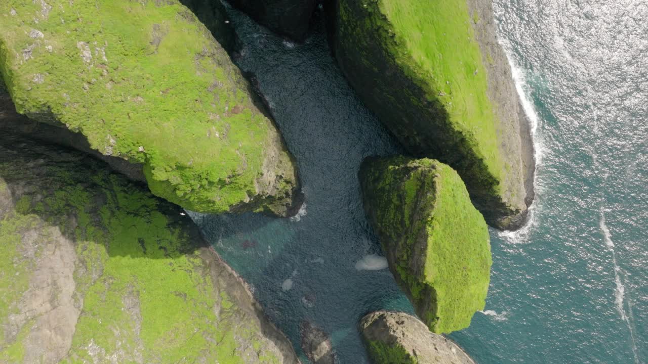 空中顶向后拍摄的自然岩层在波浪海-法罗群岛，丹麦视频素材