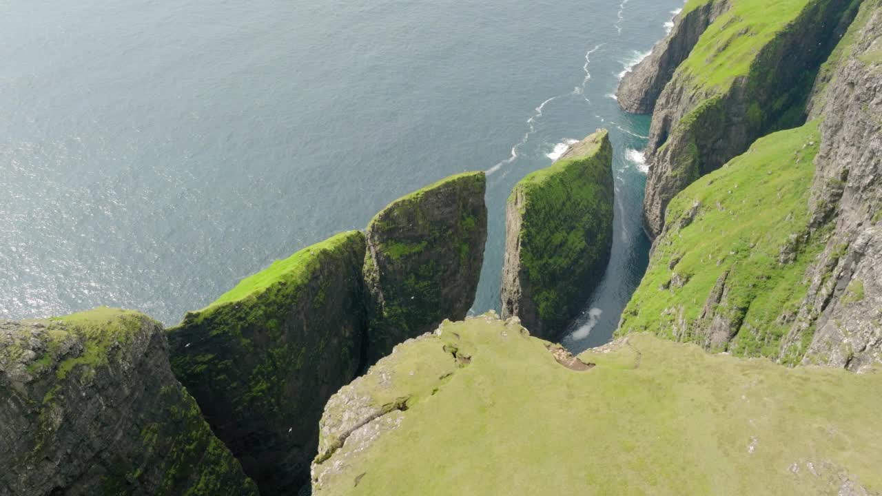 空中拍摄的海鸥飞过海洋的岩层-法罗群岛，丹麦视频素材