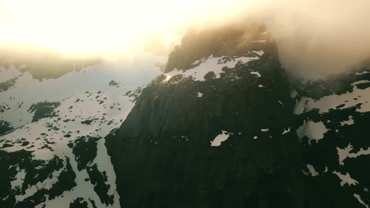 空中拍摄雪山的宁静景色，无人机向后飞越大海-挪威特罗姆瑟视频素材