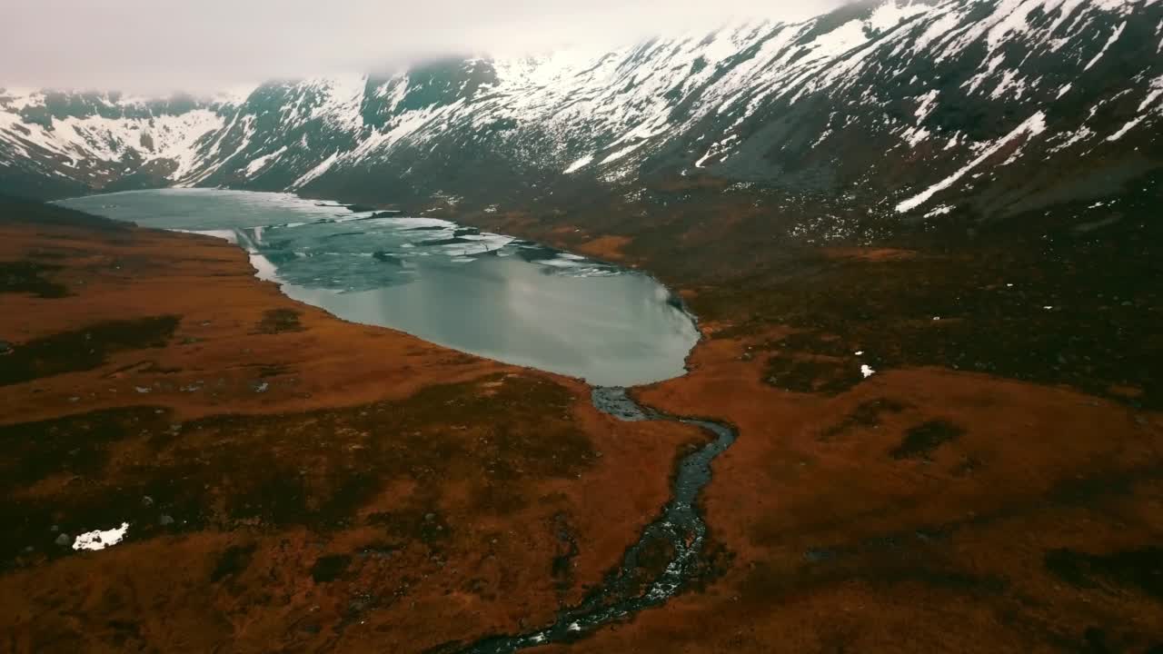 空中拍下群山中冰冻湖的美丽景色，无人机向前飞越风景——挪威特罗姆瑟视频素材