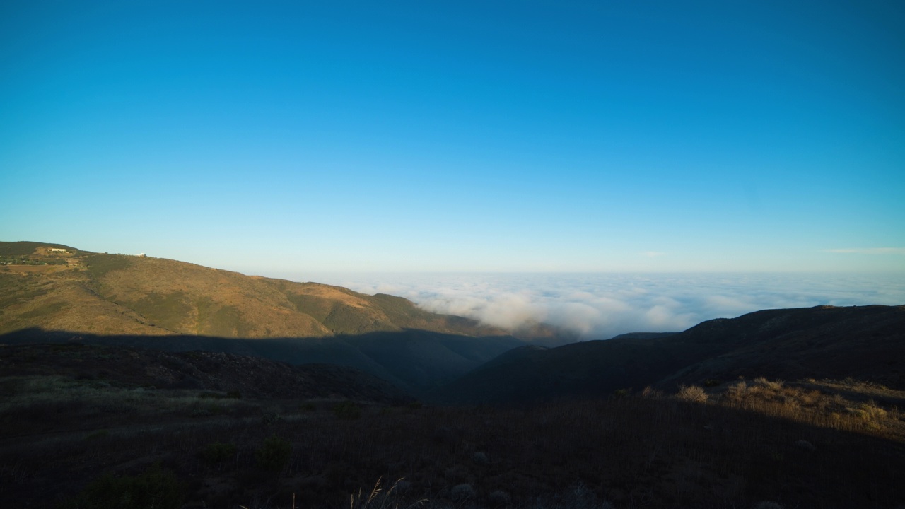 空中时间延时锁定拍摄的白色蓬松的云移动在晴朗的日子山-圣莫尼卡，加利福尼亚州视频素材