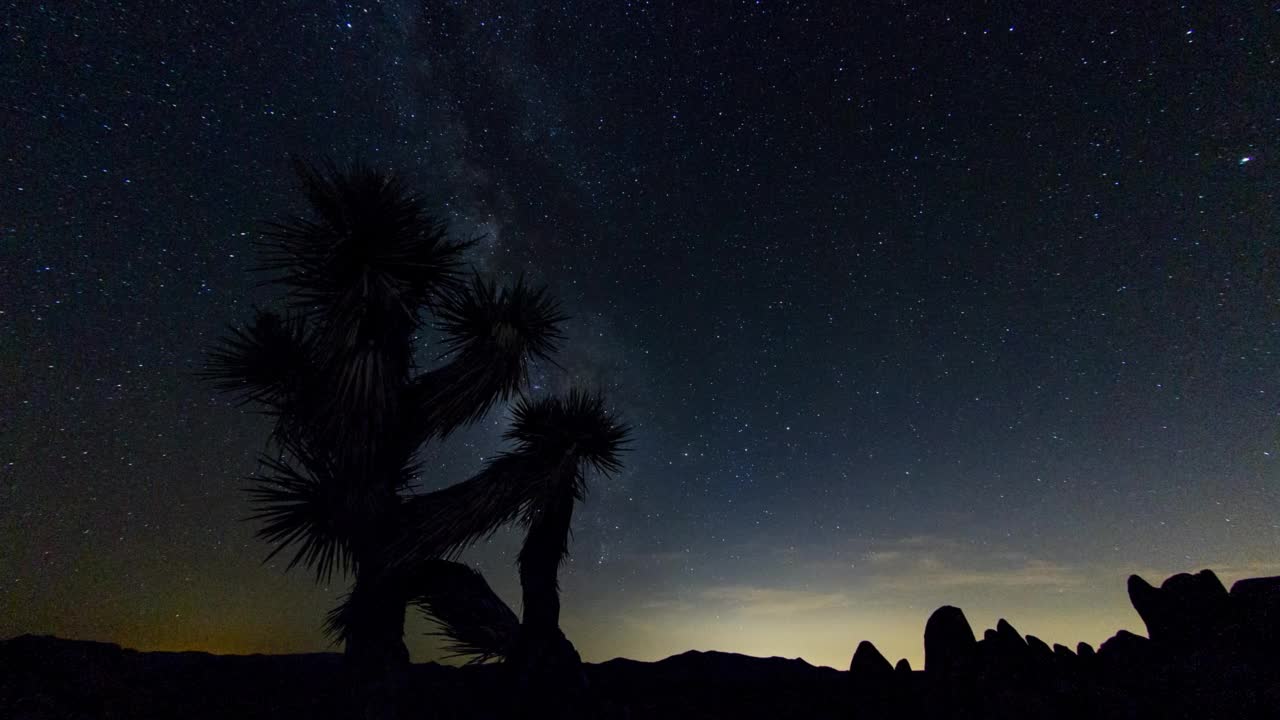 夜晚约书亚树国家公园，闪烁的星星在岩石上移动的时间间隔照片视频素材