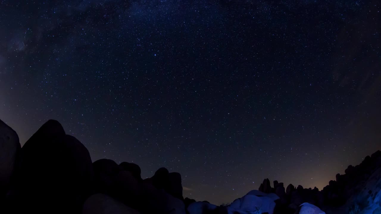 约书亚树国家公园的剪影岩石映衬着闪闪发光的星光轨迹的时间流逝镜头视频素材