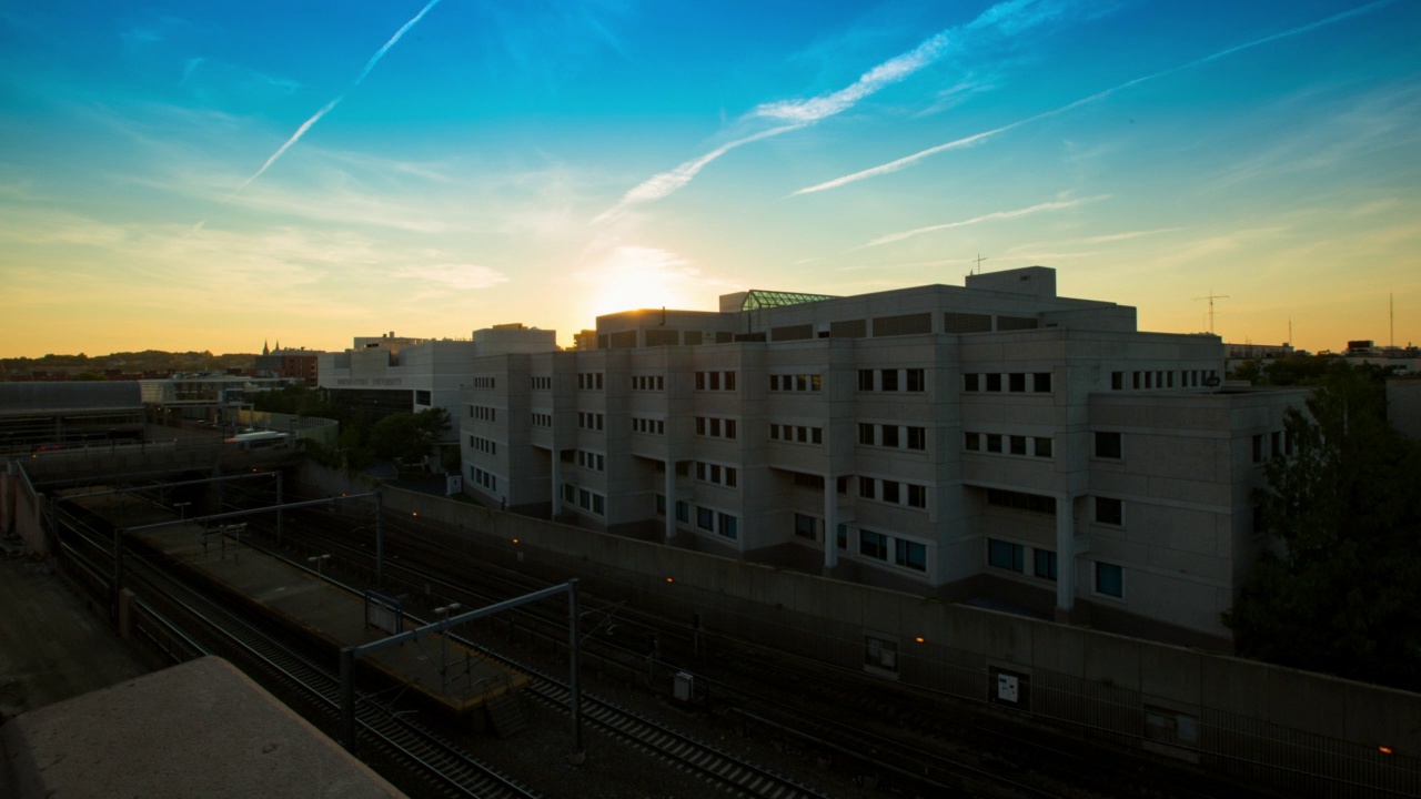 空中封锁时间拍摄的火车在轨道上移动的城市建筑物在日落-安阿伯，密歇根视频素材