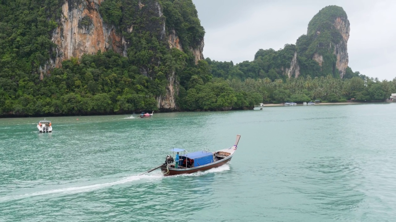 4K悬崖和甲米的海岸线上的渡轮快艇乘坐从甲米到Koh Phi Phi的旅程。清晨雾蒙蒙的渡轮拍景，船驶往热带天堂的岛屿和泻湖。泰国旅游，旅游，冒险的概念视频素材