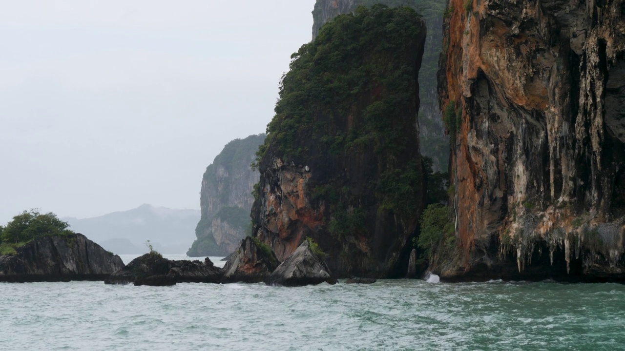 4K悬崖和甲米的海岸线在渡轮上乘坐从甲米到Koh Phi Phi的旅程。清晨雾蒙蒙的渡轮拍景，船驶往热带天堂的岛屿和泻湖。泰国旅游，旅游，冒险的概念视频素材