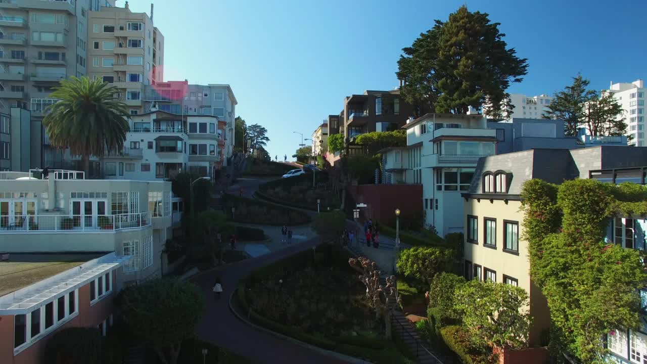 空中向前拍摄的汽车在城市住宅道路中蜿蜒的道路上，晴空万里-旧金山，加利福尼亚州视频素材