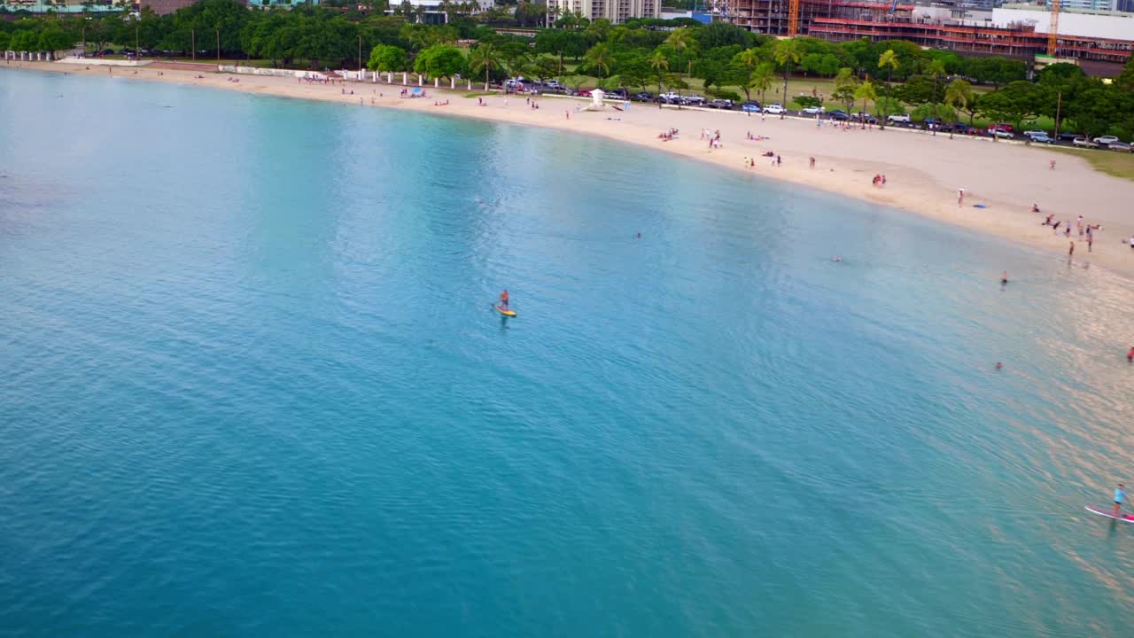 空中向后拍摄的游客在城市的海滩度假-瓦胡岛，夏威夷视频素材