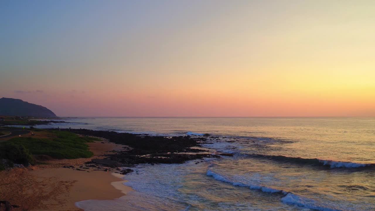 空中风景的波浪海由岛，无人机飞行向前在日落-瓦胡岛，夏威夷视频素材