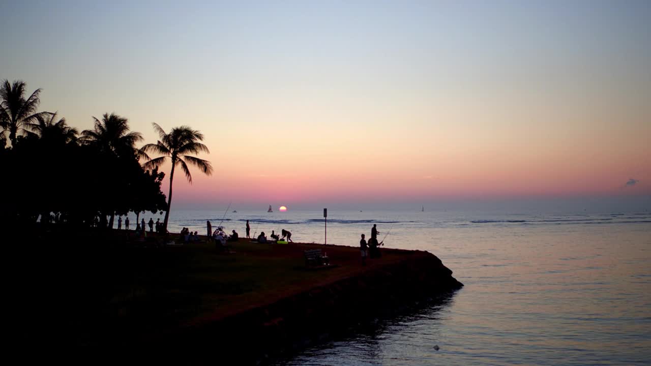 空中剪影的游客在海滩钓鱼，无人机飞行向前在波浪海-瓦胡岛，夏威夷视频素材