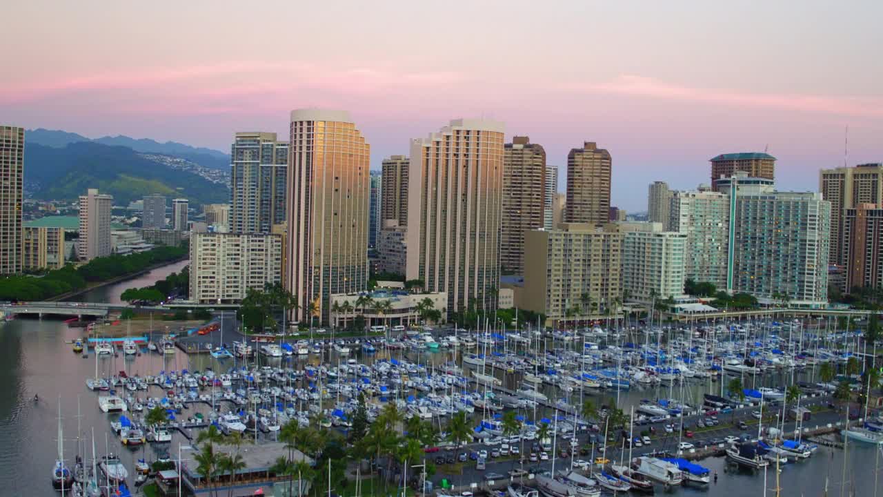 空中向后拍摄的游艇停泊在港口在城市对天空-瓦胡岛，夏威夷视频素材