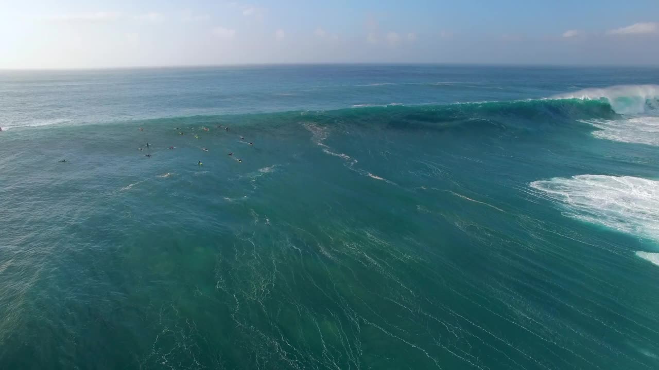 空中封锁拍摄的游客带着冲浪板在波状的海洋度假-夏威夷瓦胡岛视频素材