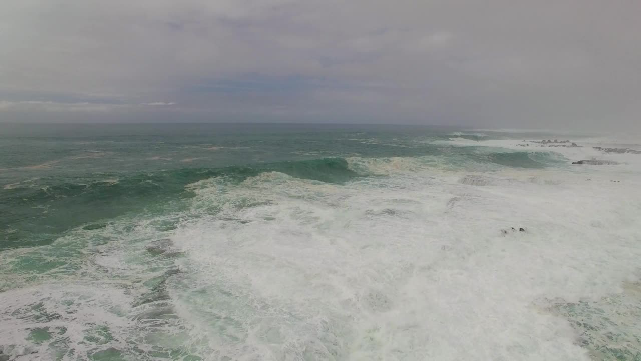 高空拍摄的多云天空下的海浪溅起的浪花——夏威夷的瓦胡岛视频素材