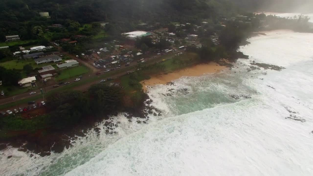 航拍:航拍汽车在岛屿景观上移动，无人机在波浪状的海岸线上向前飞行——夏威夷瓦胡岛视频素材