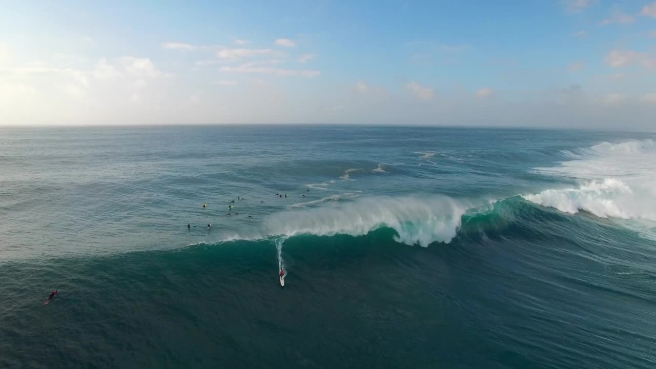 度假期间游客在波浪般的海洋上冲浪的航拍向后镜头——夏威夷瓦胡岛视频素材