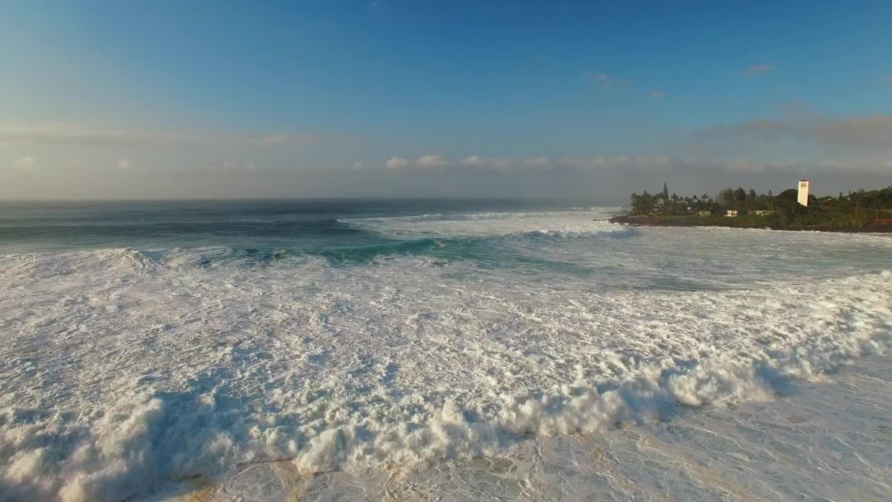 航拍:航拍欧胡岛树木的美景，无人机在波涛汹涌的海面上向前飞行视频素材