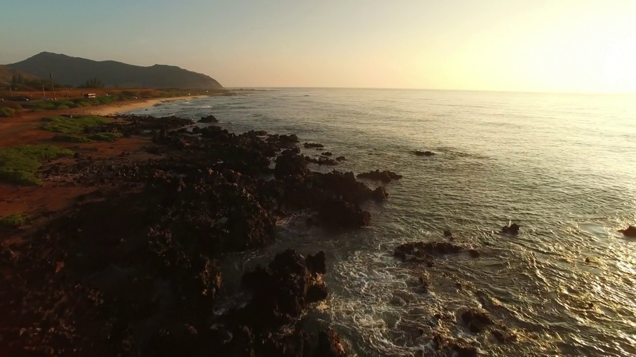 航拍:由瓦胡岛拍摄的波浪海航拍风景，无人机在日落时向前飞行视频素材