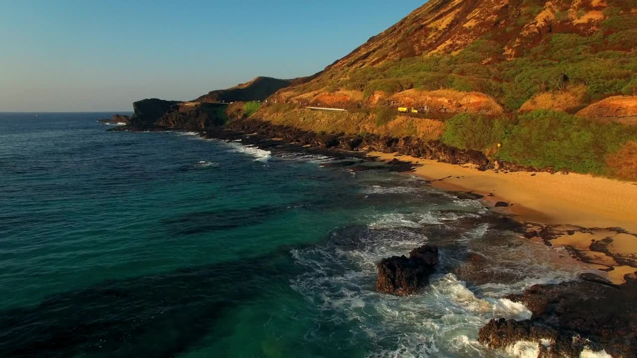 航拍:瓦胡岛岩层的航拍风景，无人机在晴朗的天空下向后飞越海洋视频素材