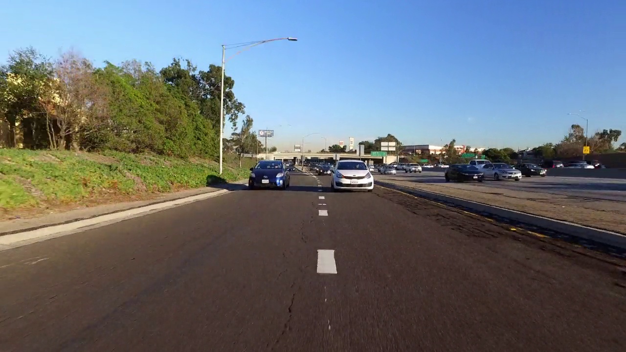 在阳光明媚的日子里，道路上行驶的车辆的时间推移视角-加利福尼亚州长滩视频素材