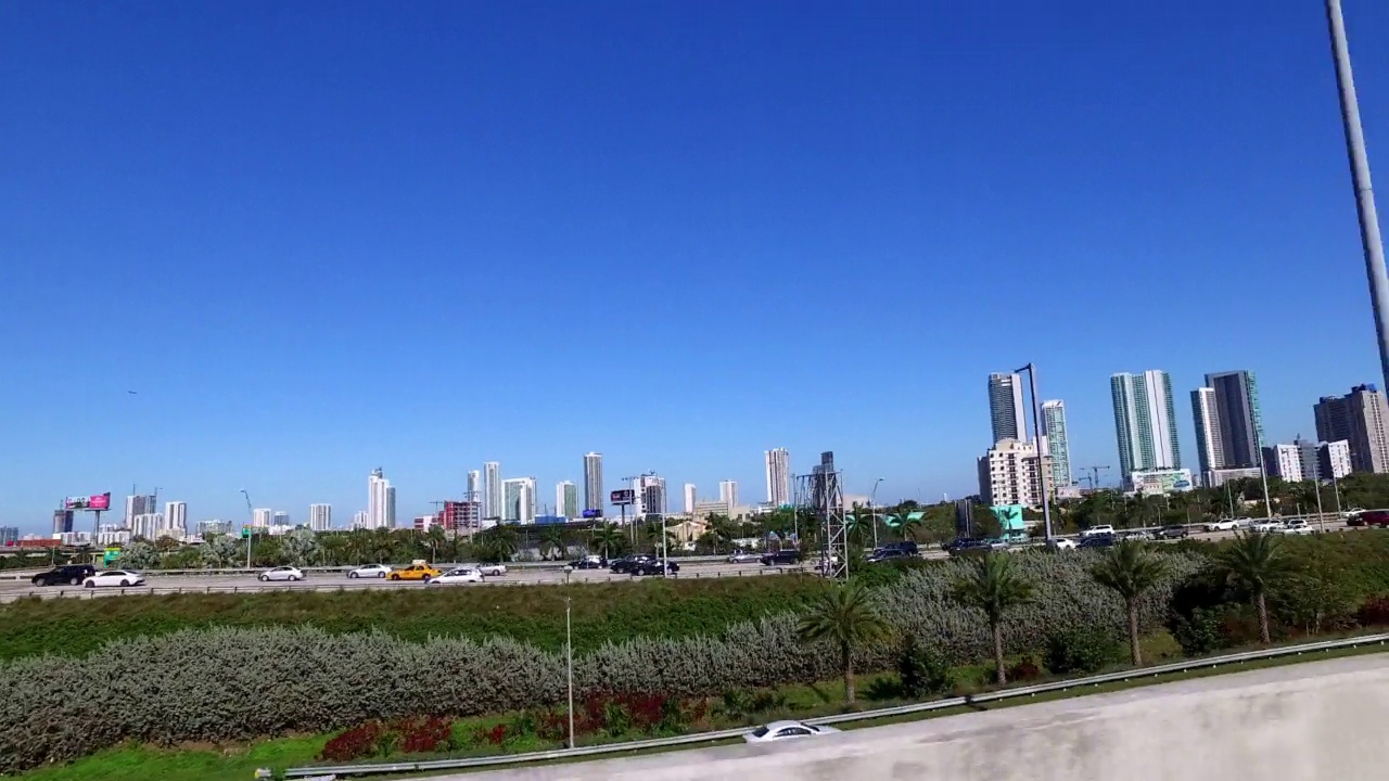 从道路上行驶的汽车看到的城市高层住宅的平移视角-迈阿密，佛罗里达州视频素材