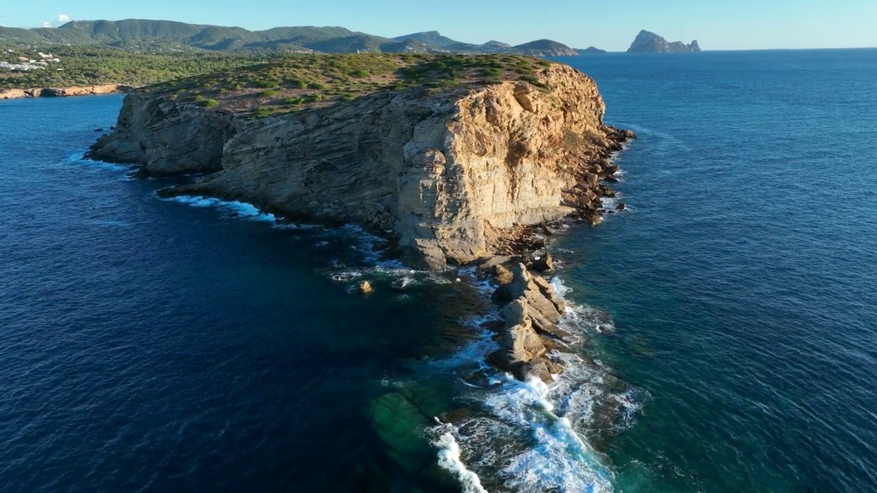 落日时分的小岛，海浪拍打着海岸的鸟瞰图视频素材